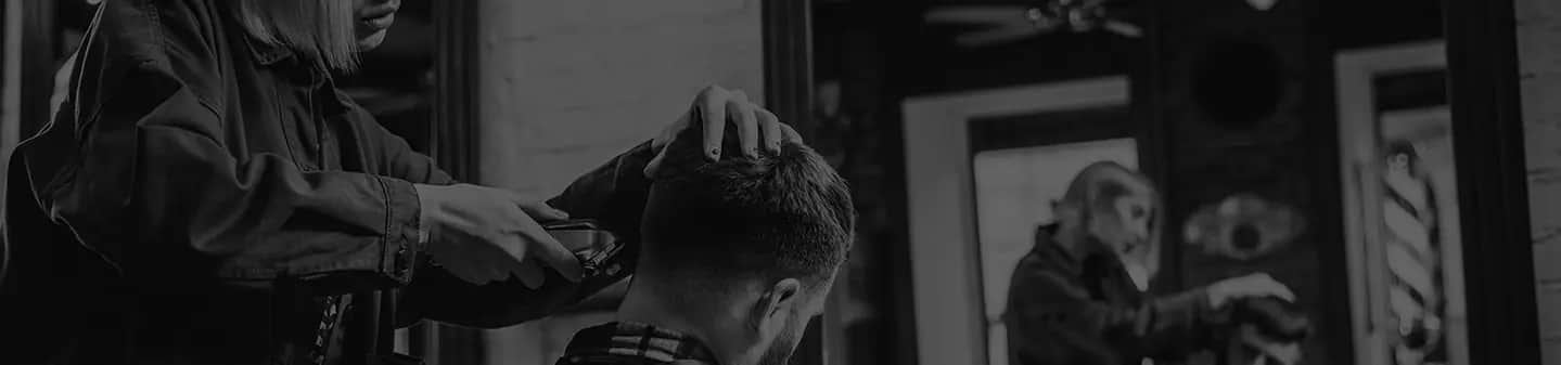Barbier réalisant un dégradé sur un client