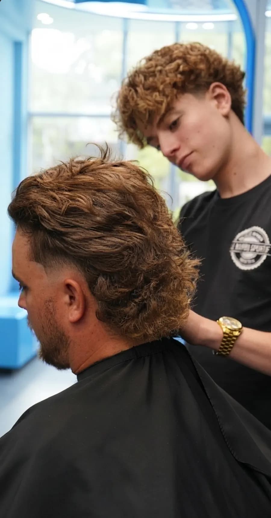 Étudiant barbier réalisant une coupe à l'Académie Barbu Sportif